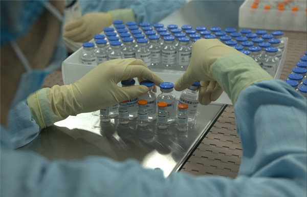 Employees prepare Clover's COVID-19 vaccine for shipment